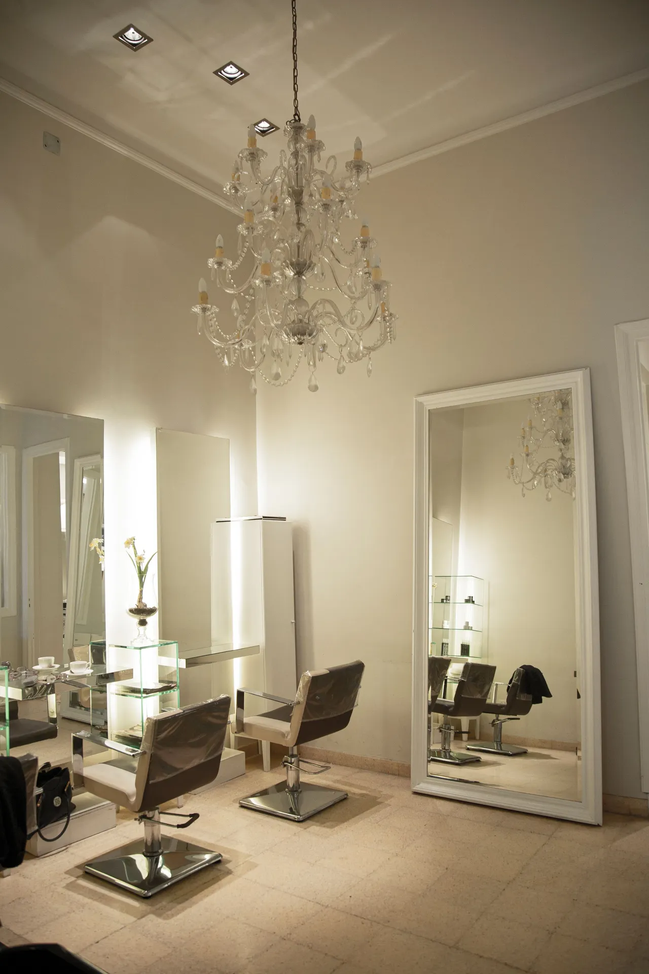 Sala do salão com candeeiro de cristal, espelhos altos e luz quente